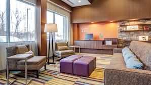 A hotel lobby with a reception desk, seating area, and large windows. - Fairfield Inn & Suites Springfield Holyoke (Holyoke)