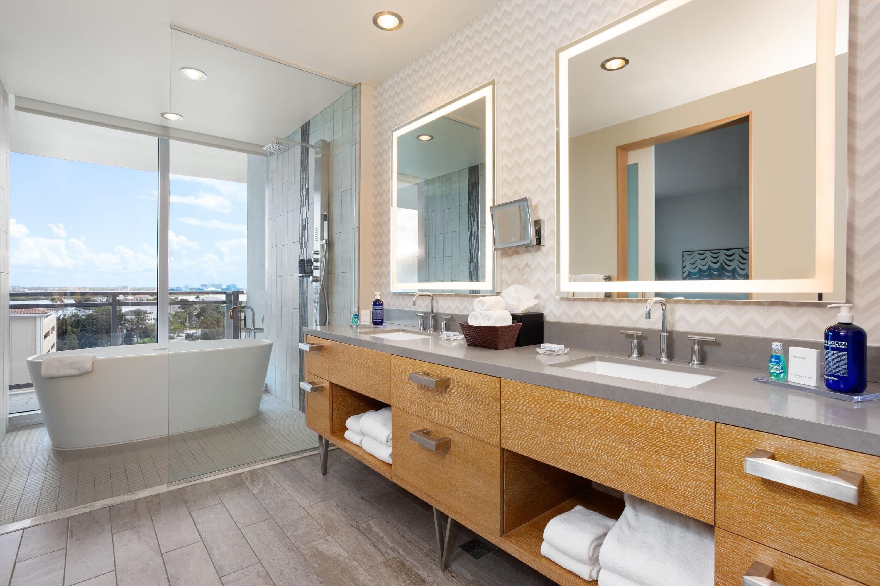 Ein modernes Badezimmer mit einer freistehenden Badewanne, zwei Waschbecken und einem großen Spiegel.