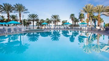 Una piscina al aire libre, sombrillas, sillones reclinables de piscina