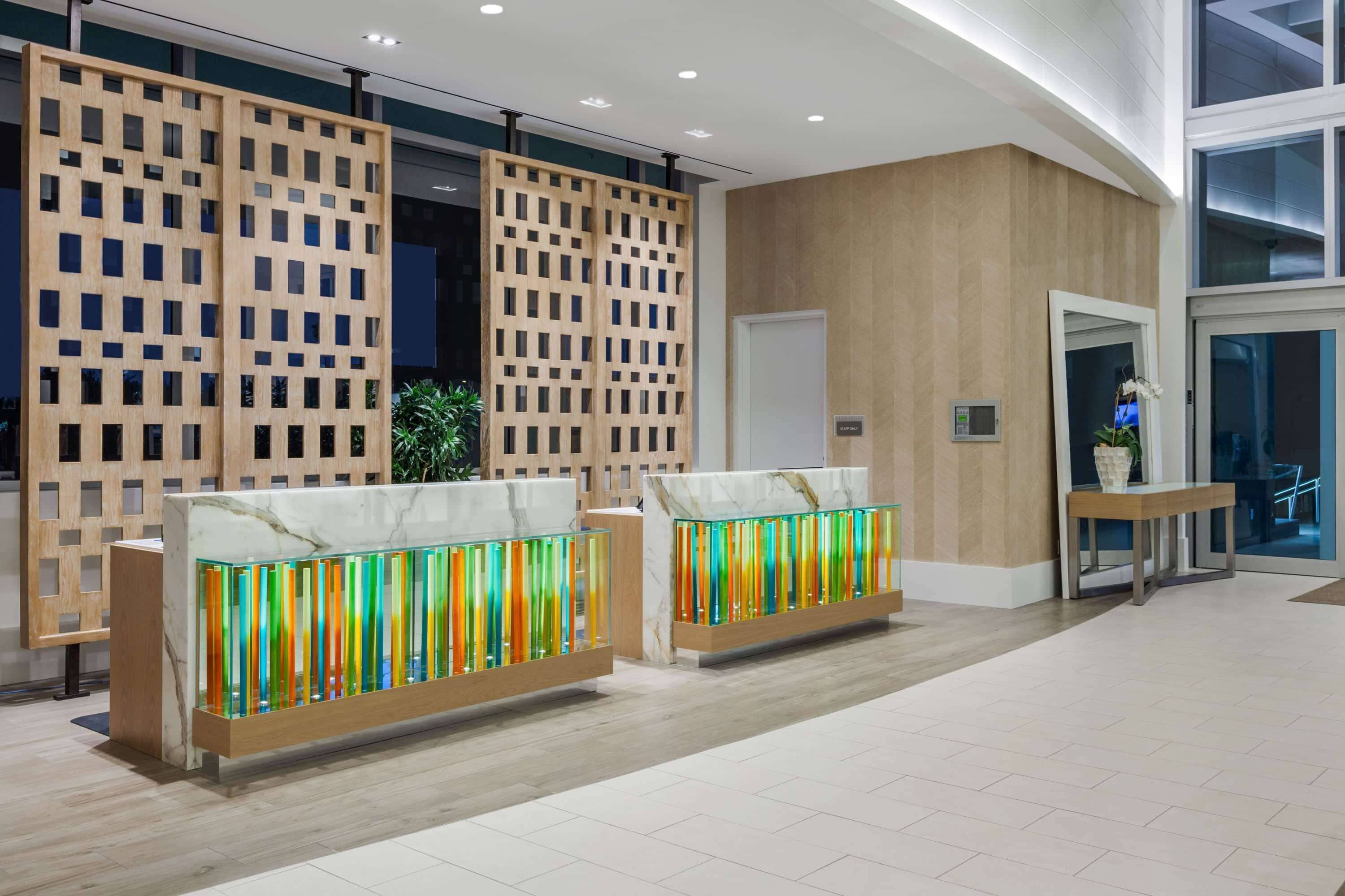 Una zona de recepción con separadores de madera, un mostrador de mármol y un diseño de interiores moderno.