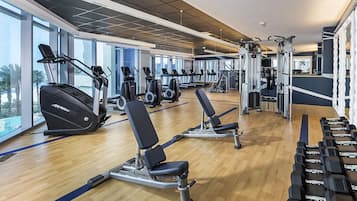 Una palestra con macchinari cardio, panche per pesi e pesi liberi.