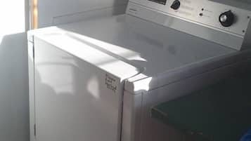 Un lave-linge à chargement frontal doté d’un panneau de commande et d’une étiquette sur la porte.