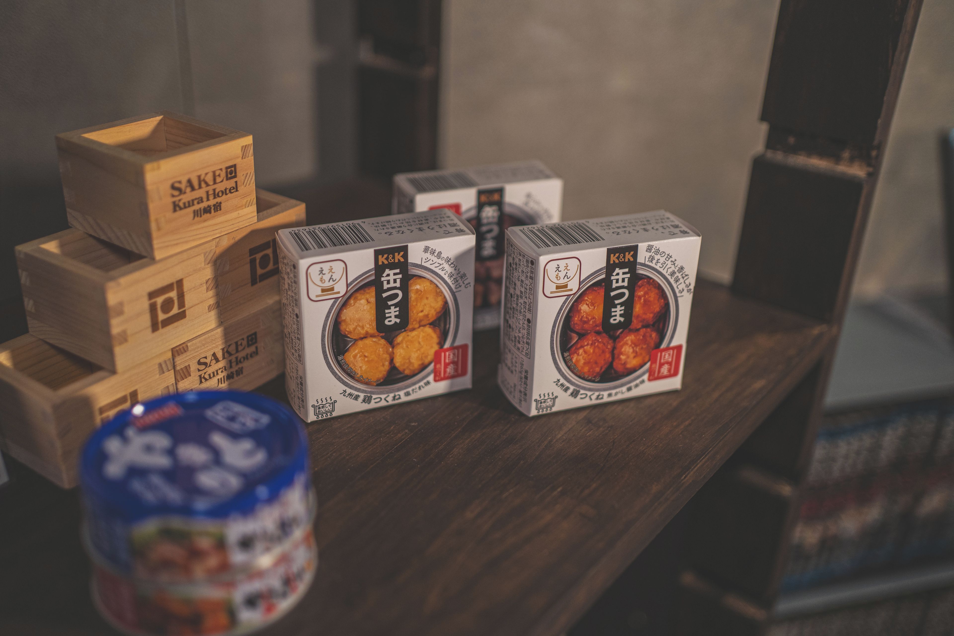 A stack of wooden crates and several boxes of K&K products on a wooden surface.