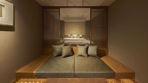 A room with a bed, a sofa, and a wooden floor. - SAKE Kura Hotel Kawasaki Shuku (Kawasaki)