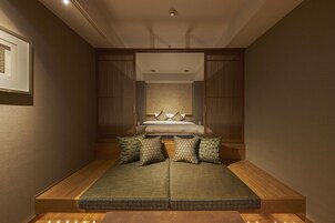 Una habitación con cama, sofá y suelo de madera.