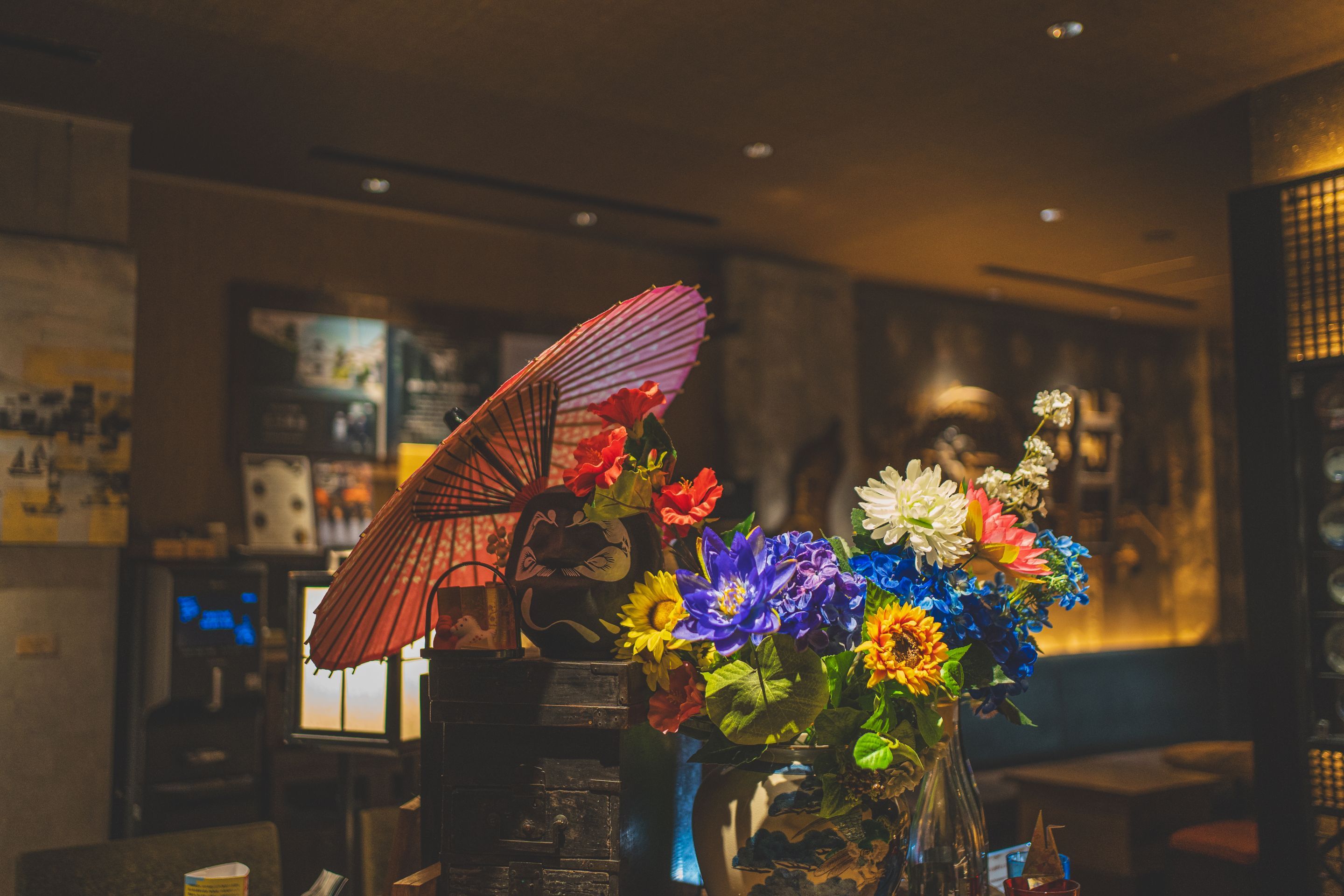 A table with a vase of flowers and a decorative umbrella.