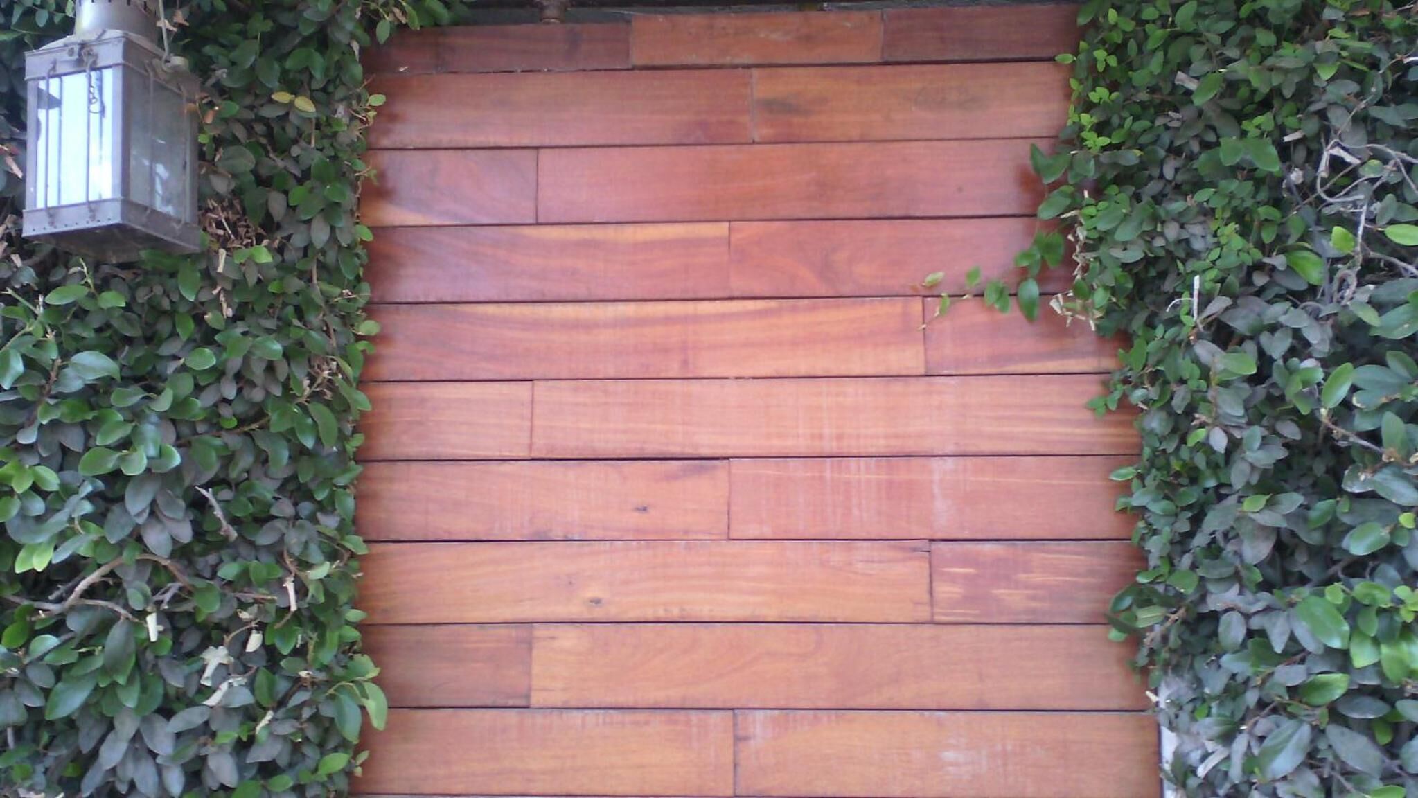 A wooden wall with a lantern hanging on it.