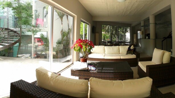 A spacious living area with a large window, a staircase, and a sofa set.