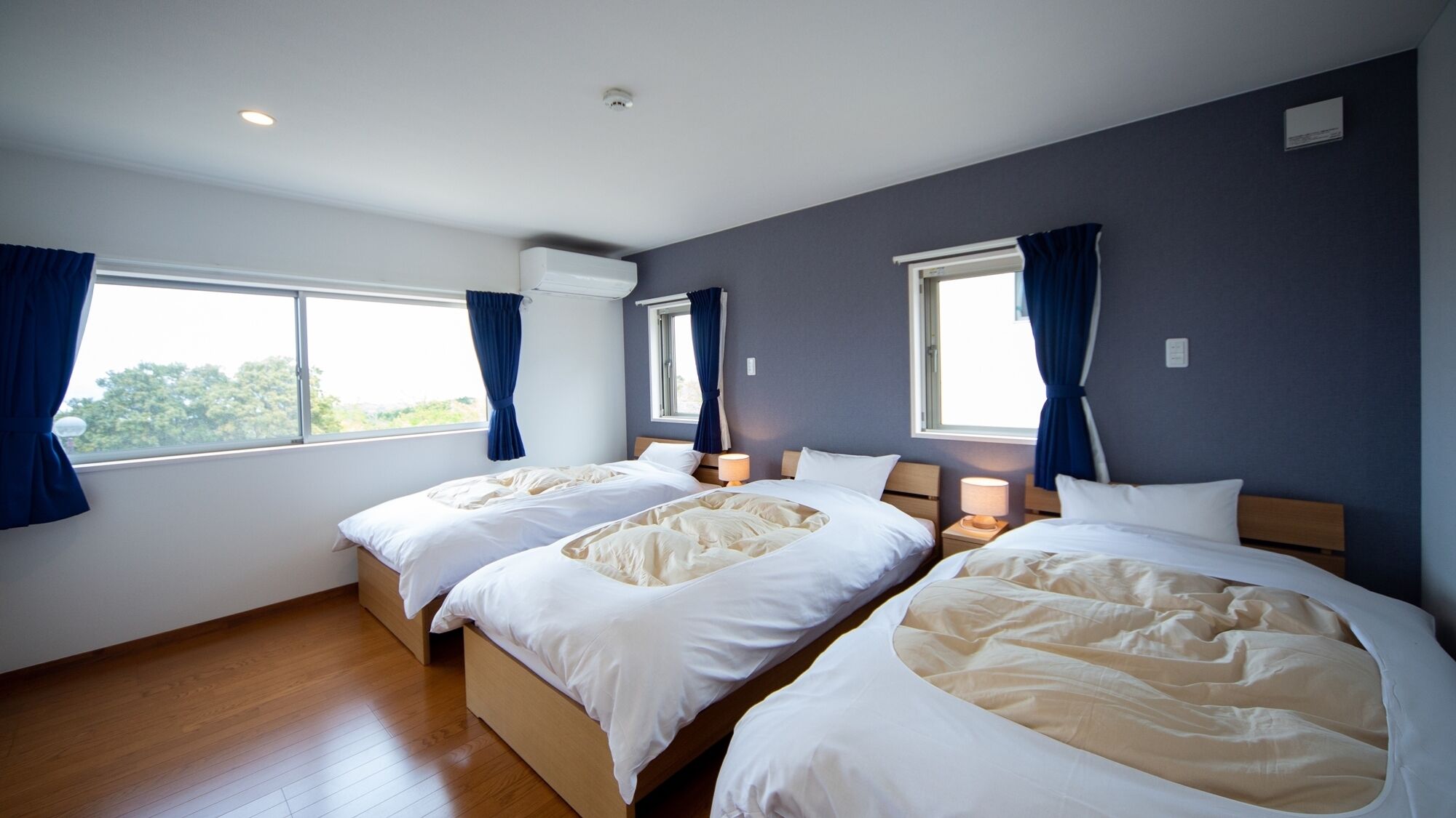 Ein Hotelzimmer mit zwei Betten, einem Fenster und einer Klimaanlage.