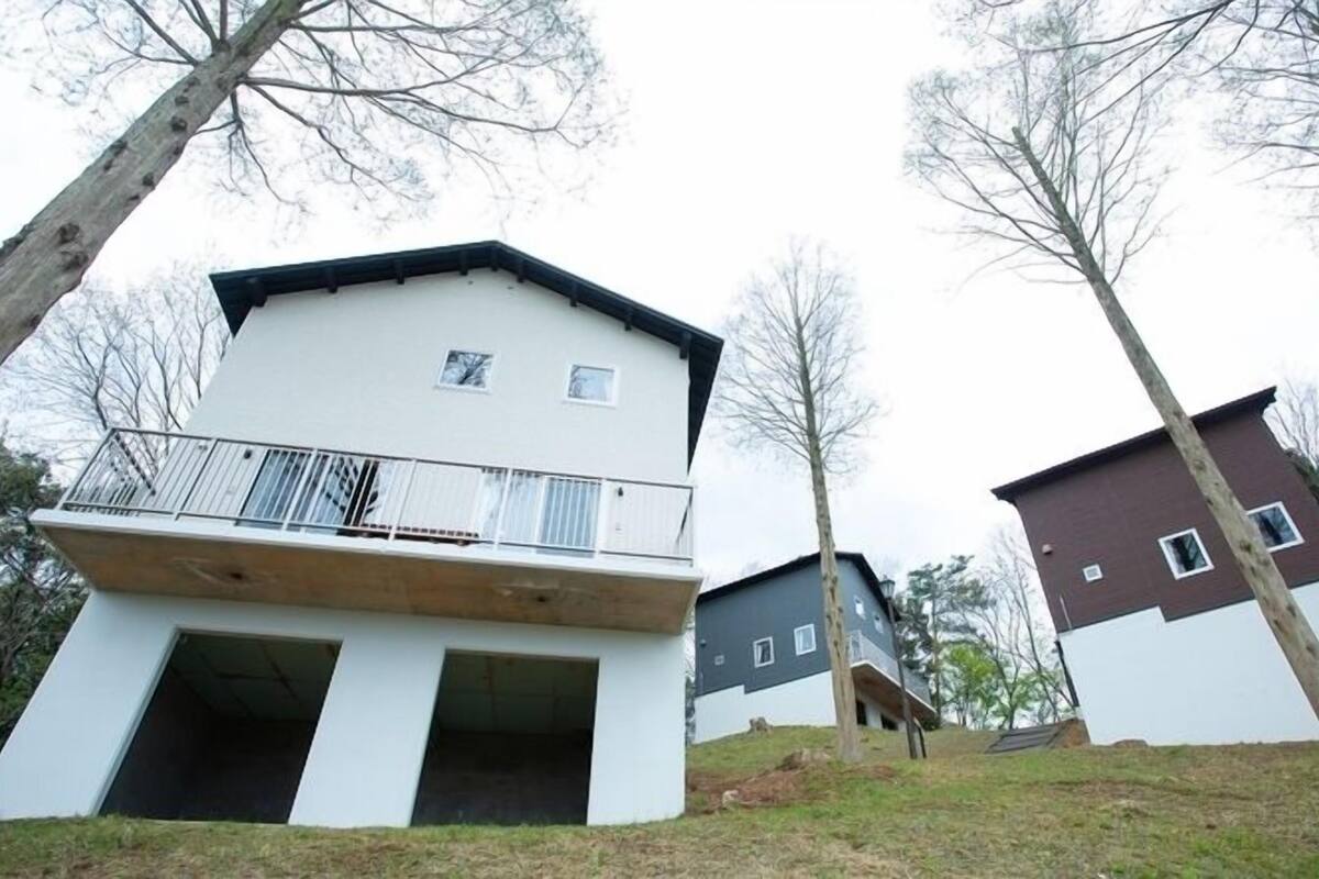 Un immeuble résidentiel de deux étages doté d’un balcon, d’un toit plat et d’une petite fenêtre.