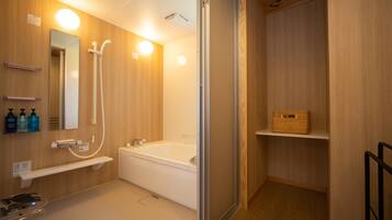 Un baño moderno con tocador de madera, un espejo grande, una bañera y zona de ducha.