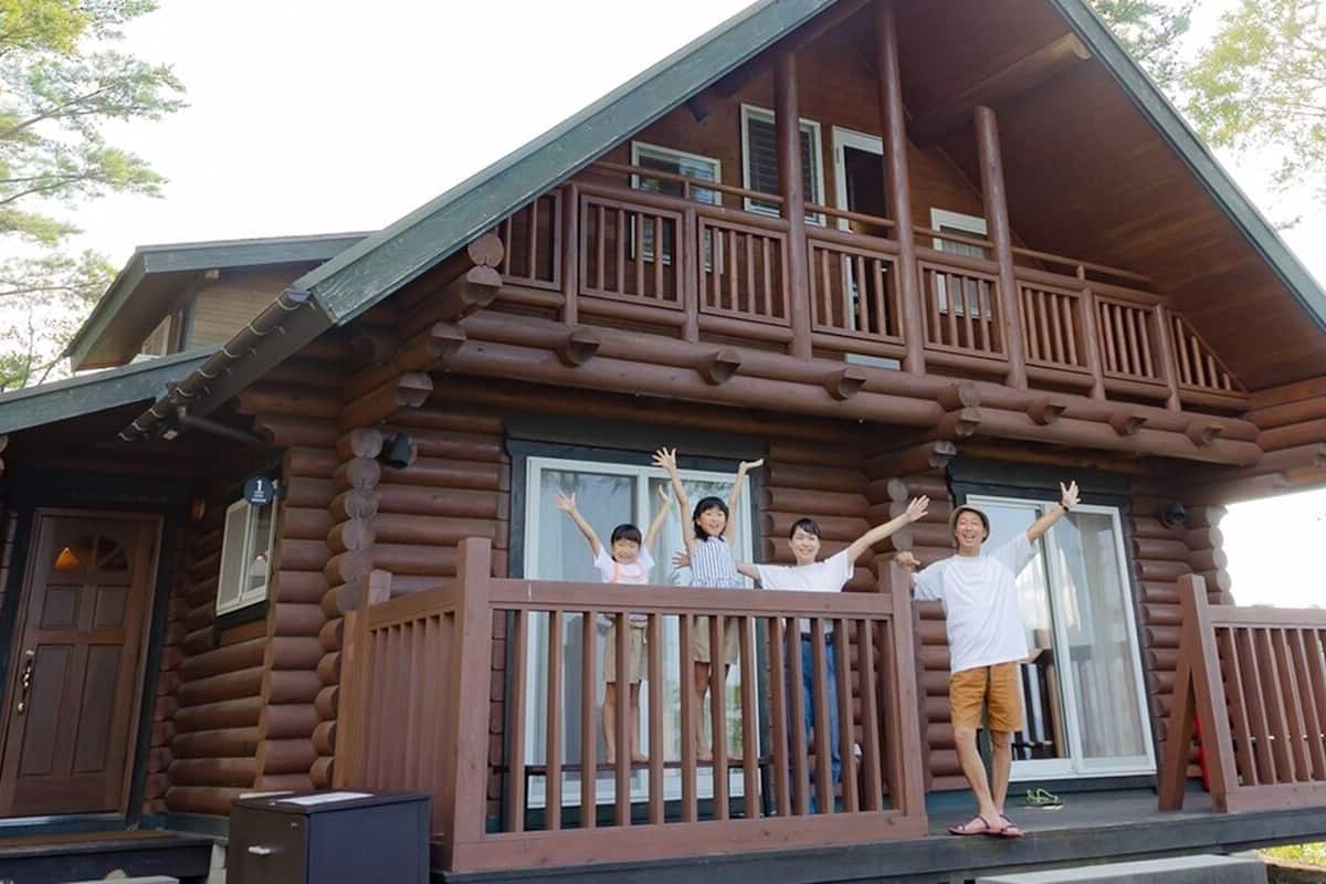 Eine Blockhütte mit Balkon, einer Haustür und einem Fenster.