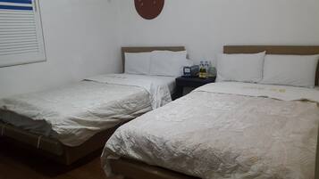 Two single beds with white linens in a room.