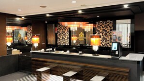 A modern hotel lobby with a reception desk, seating area, and a large mirror reflecting the interior. - APA Hotel TKP Sapporoeki-Kitaguchi EXCELLENT (Sapporo)