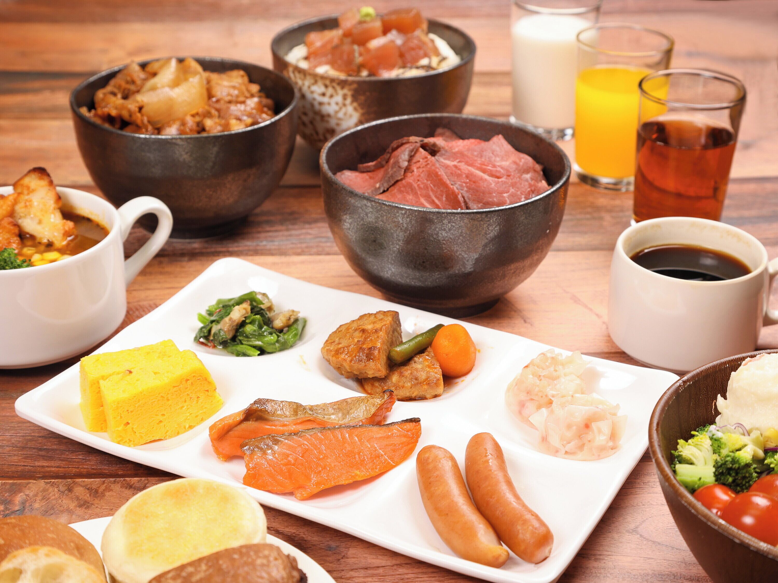 A variety of dishes including fish, vegetables, and bread on a wooden table.