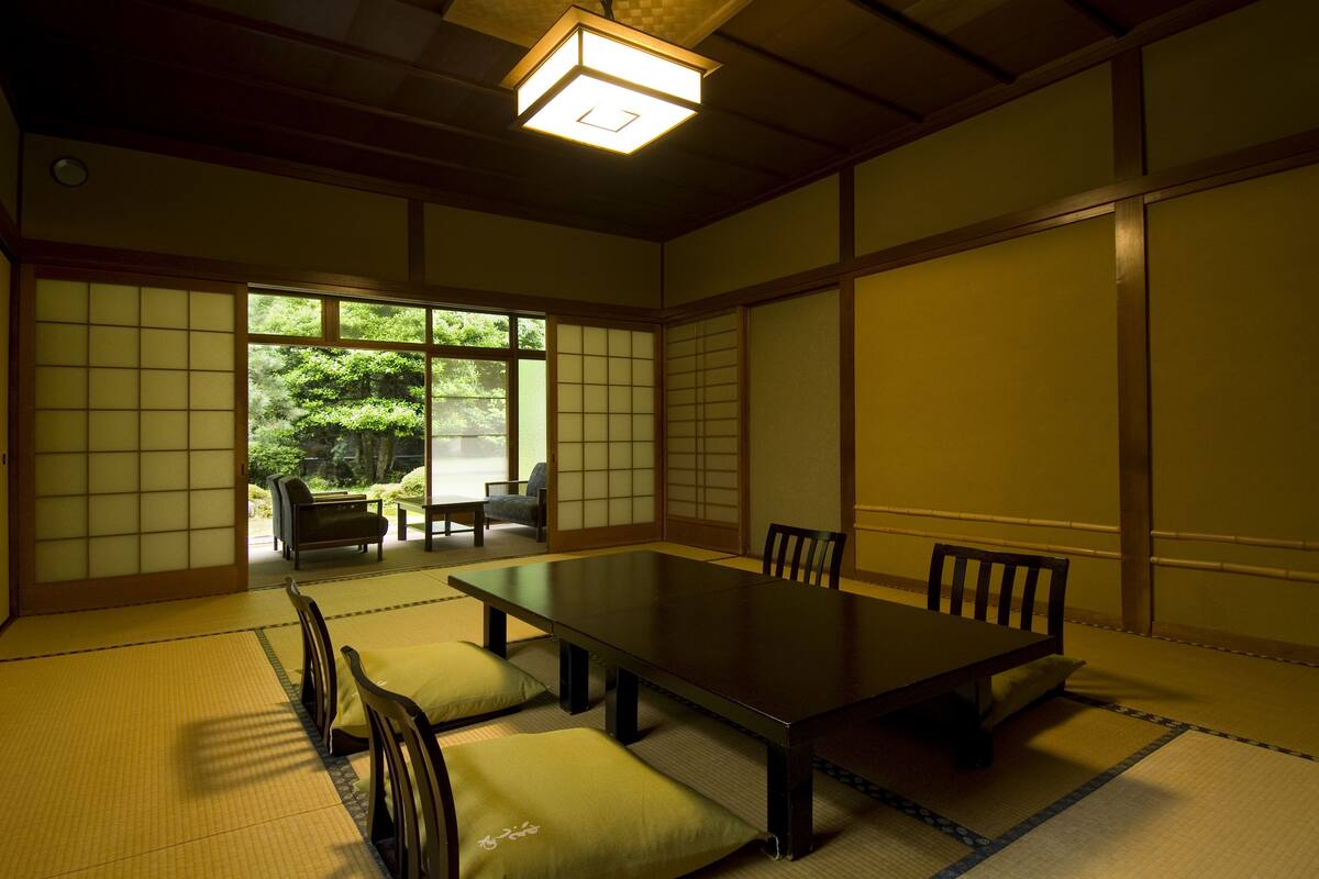 A traditional Japanese room with tatami flooring, a low table, and sliding doors.
