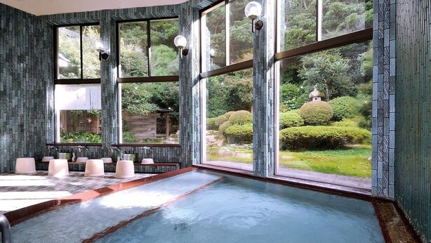 Un área de spa con un ventanal grande, una bañera de hidromasaje y una fila de lavamanos.