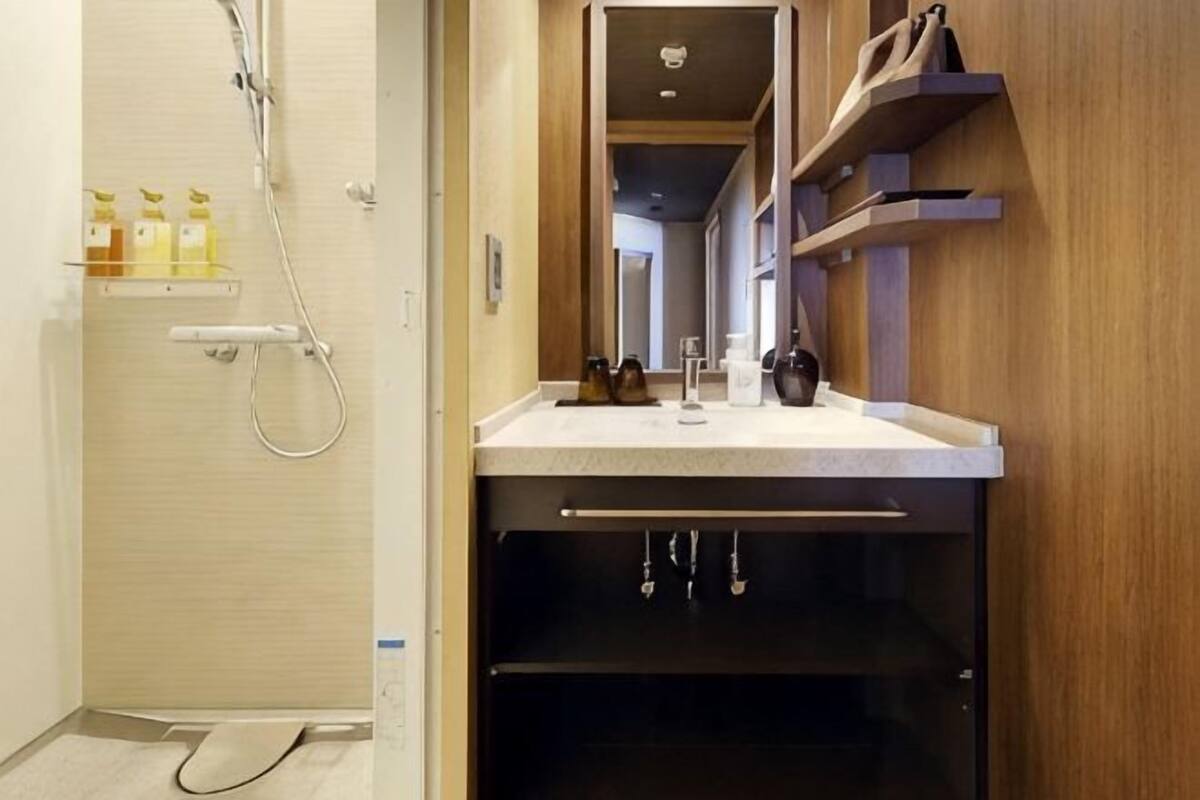 A bathroom with a shower, a sink with a mirror, and a towel rack.