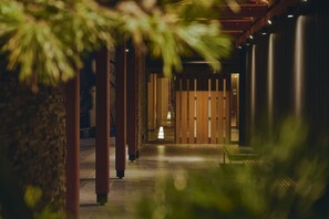 A corridor with wooden pillars, a bench, and a view into a room with a lamp. - Hakodate Hotel Banso(ORIX HOTELS & RESORTS) (Hakodate)