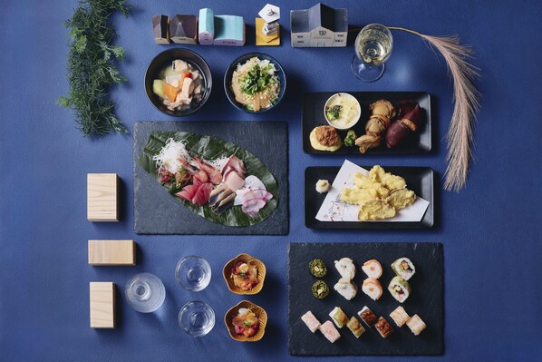 A variety of Japanese dishes arranged on a blue table, including sushi, sashimi, and other delicacies. - Hakodate Hotel Banso(ORIX HOTELS & RESORTS) (Hakodate)