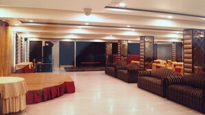 A spacious room with a stage, sofas, and a fireplace.
