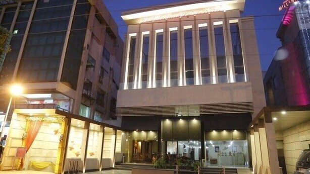 A modern hotel with a prominent entrance, large windows, and a well-lit facade.