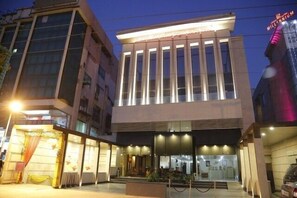 A modern hotel with a prominent entrance, large windows, and a well-lit facade. - Mahalakshmi Palace hotel (Faridabad)