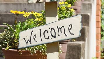A wooden welcome sign with the word "Welcome" on it.