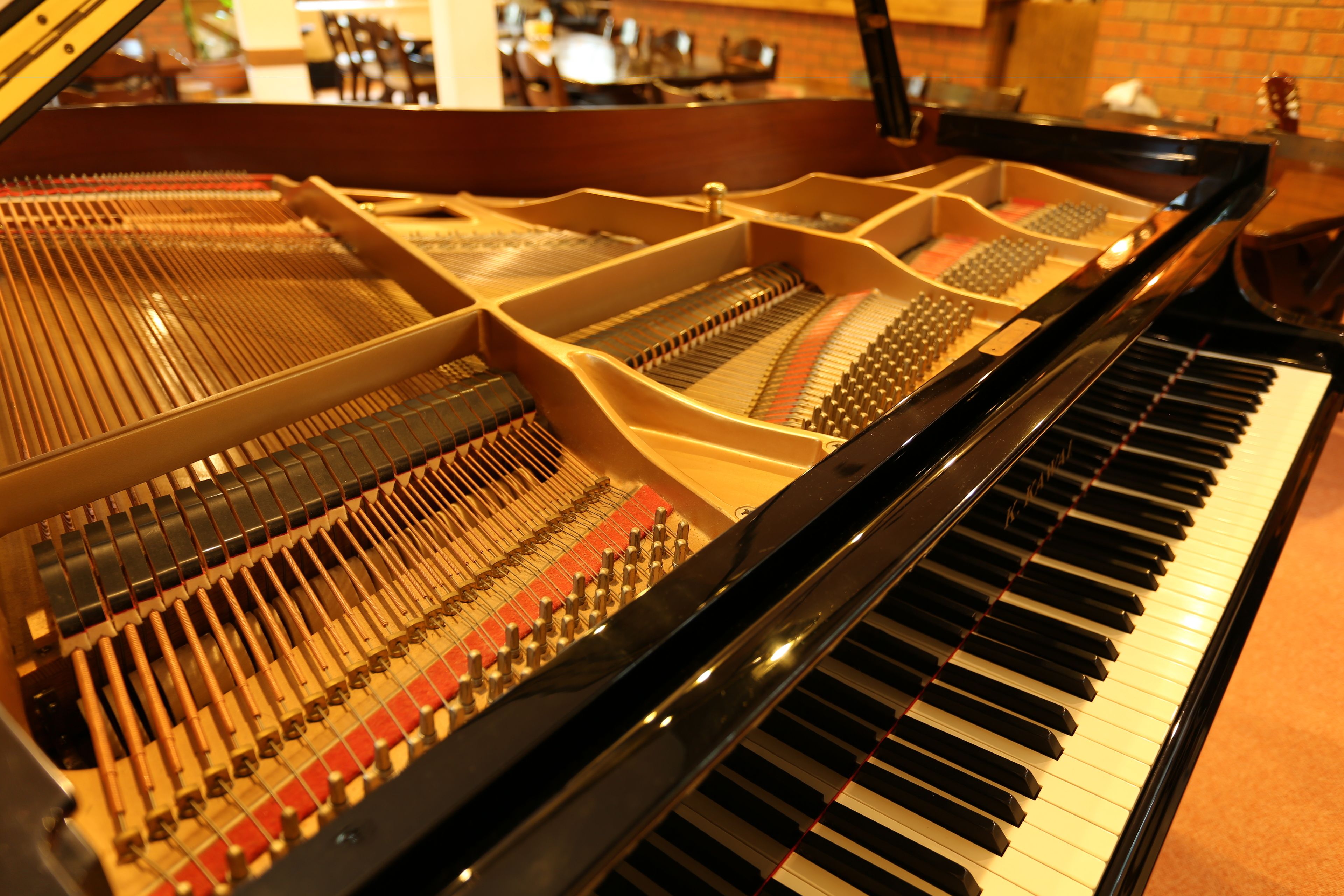 Un piano à queue doté d’une finition noire brillante et d’un mécanisme interne complexe.