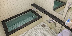 Kombinasi shower/bathtub, sandal,  dan handuk