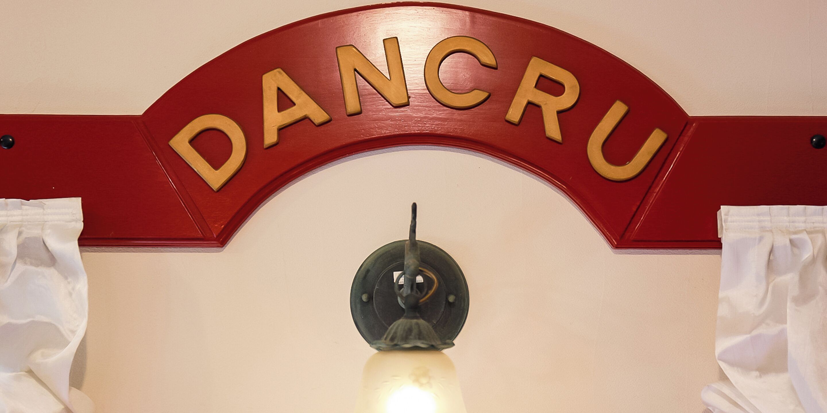 A red sign with the word "DANCRU" in gold letters.