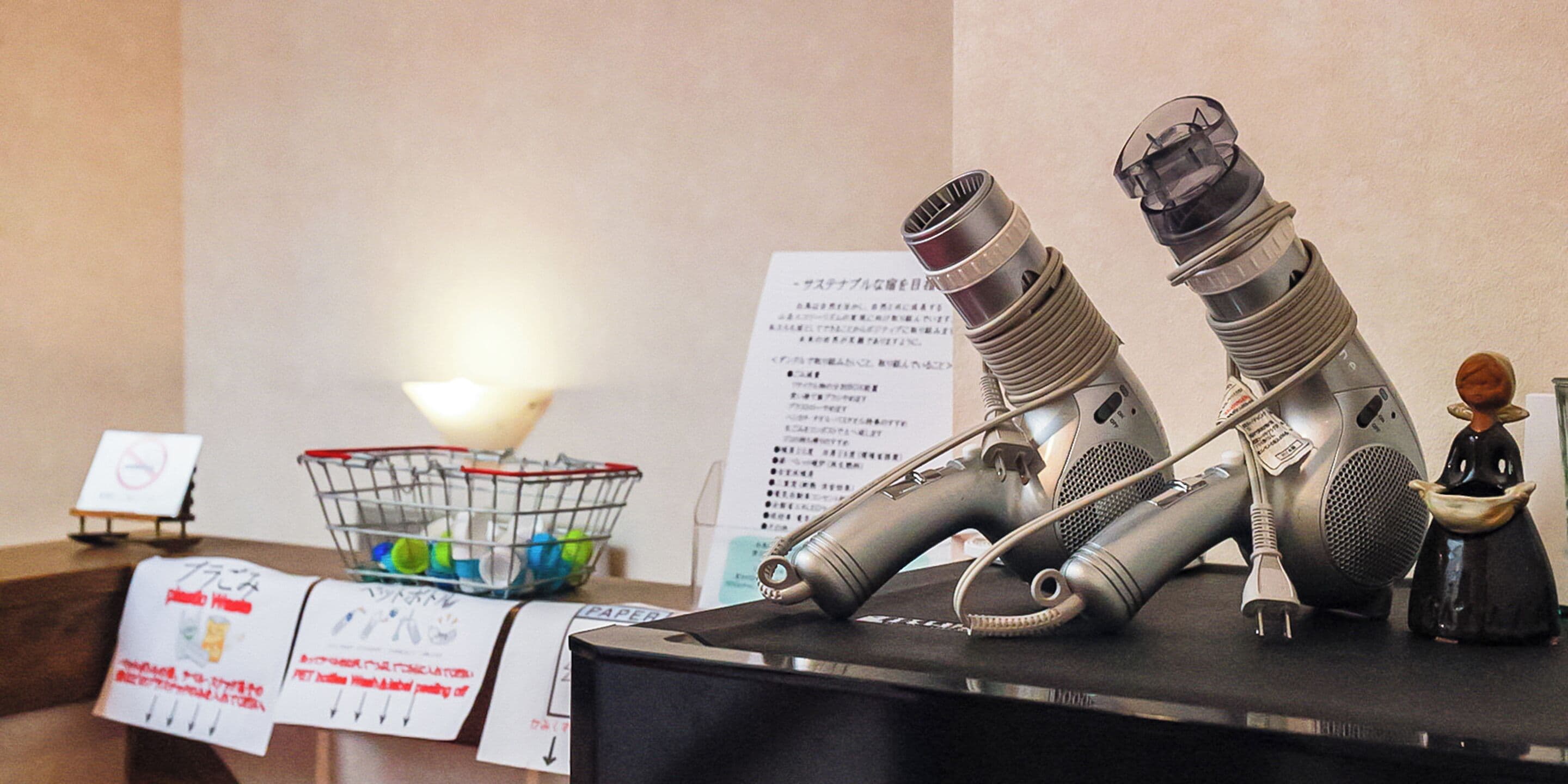 A desk with a pair of headphones, a small figurine, and a paper sign with instructions.
