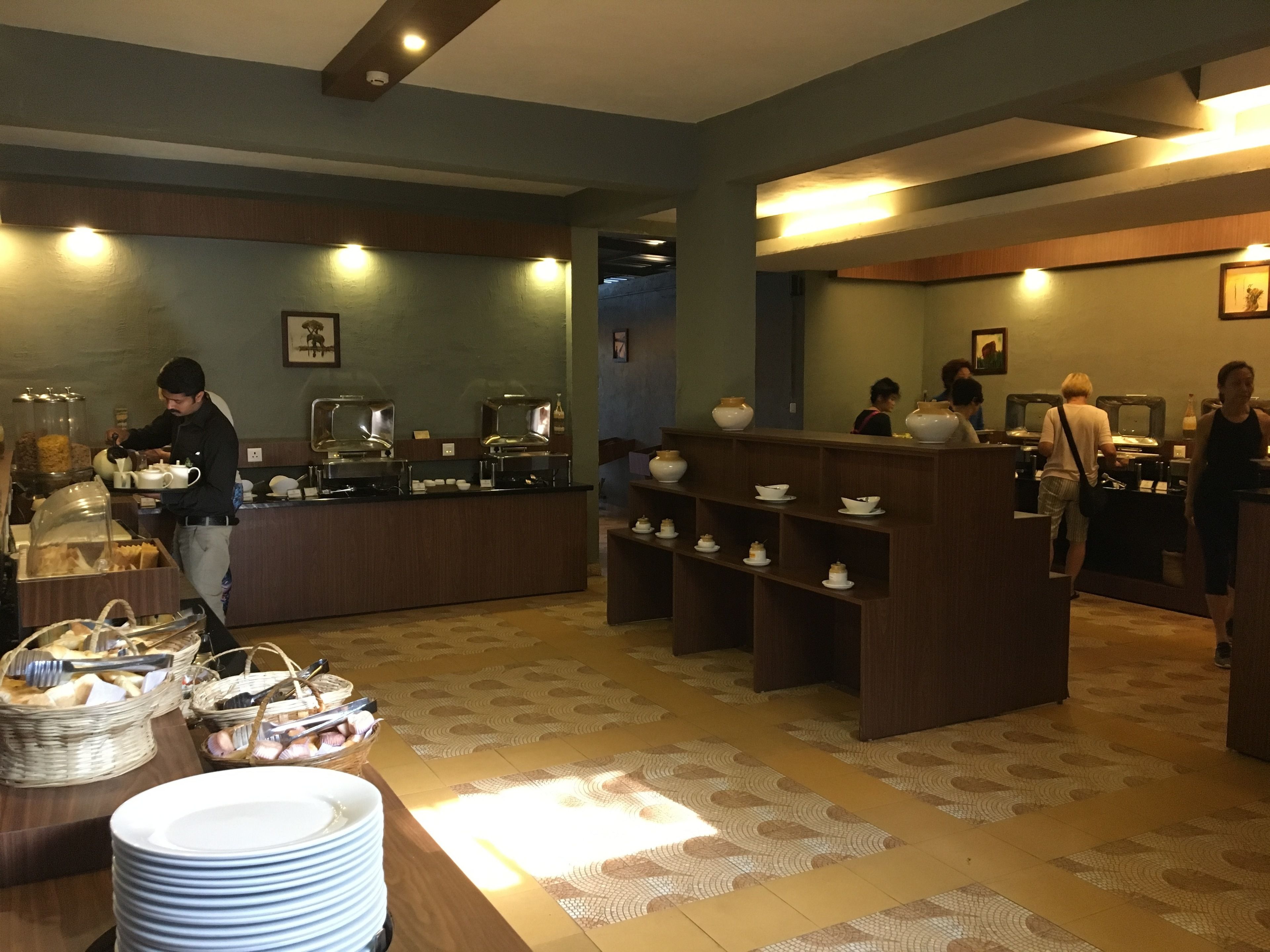 A buffet area with multiple serving stations, a counter with a variety of dishes, and a seating area with tables and chairs.