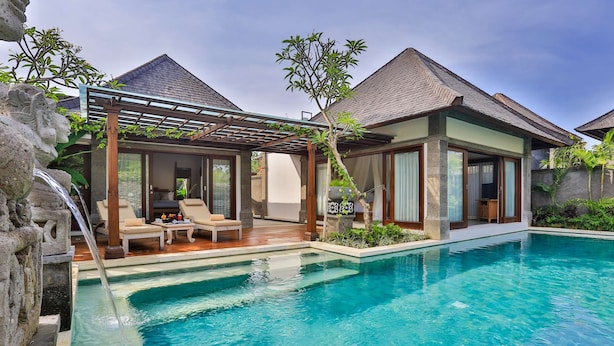 A modern poolside area with a clear pool, lounge chairs, and a pergola. - Visesa Ubud Resort (Ubud)
