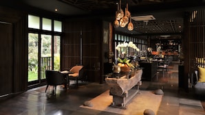 A modern interior with a stone bench, seating area, and a view of the outdoors. - Visesa Ubud Resort (Ubud)