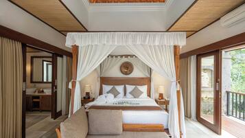 A spacious bedroom with a canopy bed, a balcony, and a view of greenery.