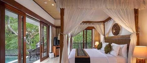 A spacious bedroom with a large bed, a canopy, and a view of the outdoors.