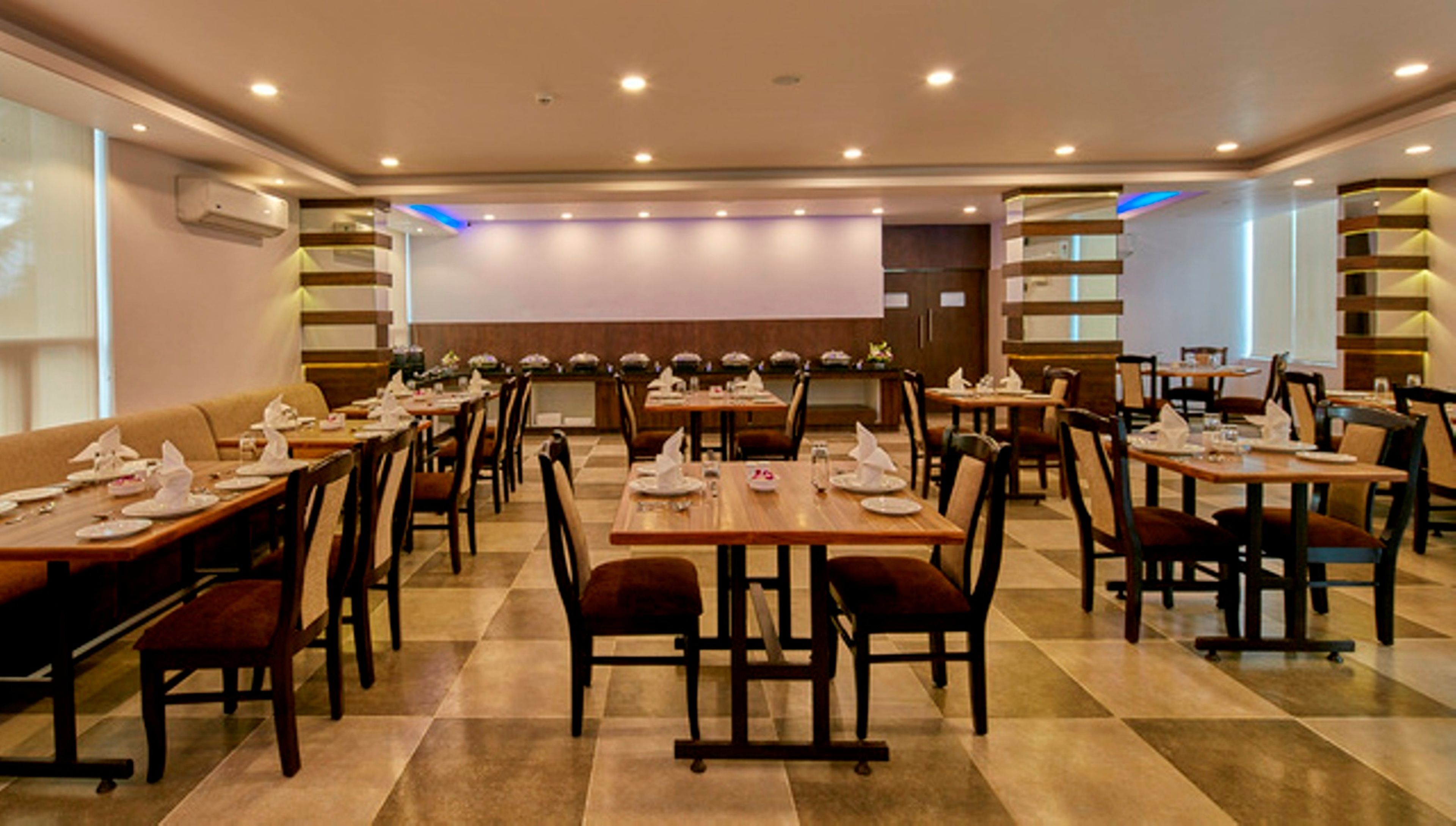 A spacious dining area with multiple tables and chairs, arranged in a symmetrical layout.