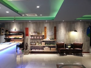 Interior de restaurante con paneles de madera, una barra con varios objetos y dos sillones de cuero.
