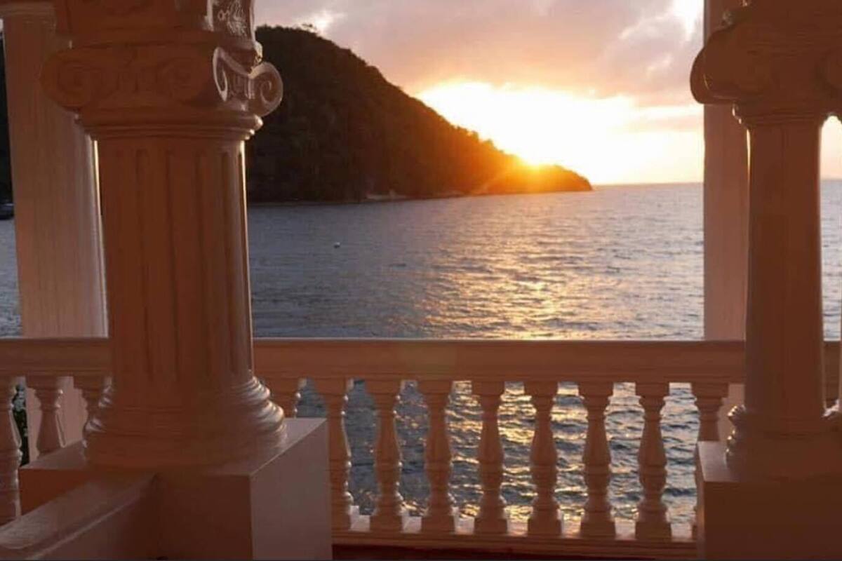 Un balcon avec vue sur la mer et sur le coucher du soleil.