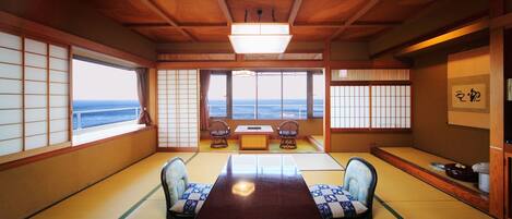 Une pièce de style japonais traditionnel, avec un sol recouvert de tatamis, une table basse et des portes coulissantes.