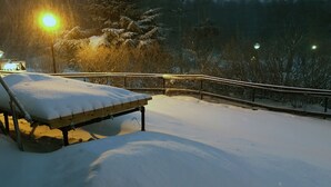 Area esterna innevata con una panchina e una recinzione.