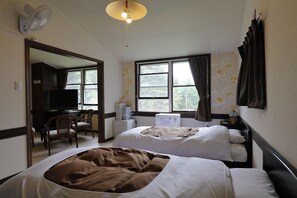 A hotel room with two beds, a desk with a chair, a television, and a window with curtains.