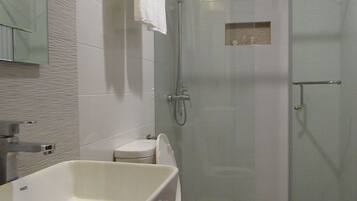 Ein modernes Badezimmer mit Badewanne, Toilette und Duschkabine.