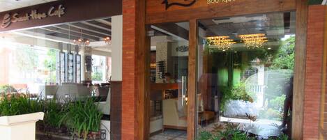Hotel Boutique Sweet Home con una entrada moderna, plantas de interior y un área de descanso visible.