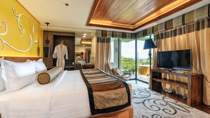 Un dormitorio amplio con una cama grande, televisión y un balcón con vistas.