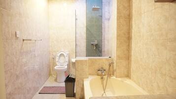 A bathroom with a toilet, shower, and bathtub.