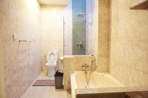 A bathroom with a toilet, shower, and bathtub.