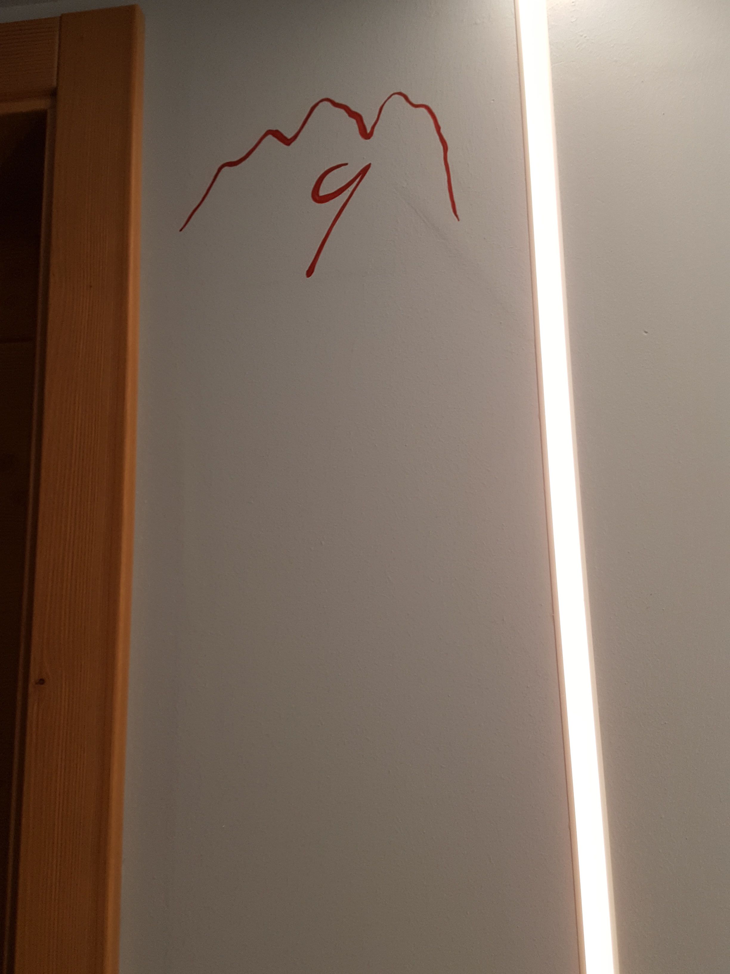 A whiteboard with a red drawing of a mountain and the number 9.