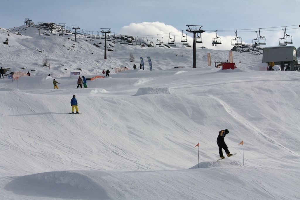 Eine Skipiste mit einer Seilbahn und ein paar Skifahrern.